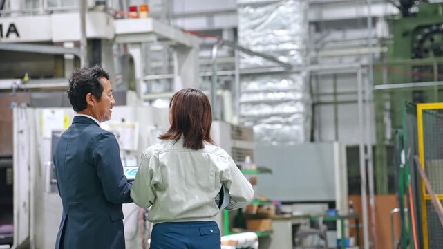 Businessman and worker inspecting a factory