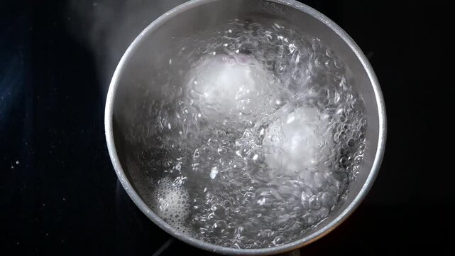 Boiling eggs in a pot on the stove with steam