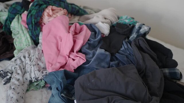 Clothes piling up on the bed needs sorting and organizing