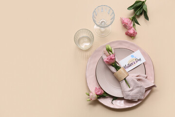 Beautiful table setting with greeting card and eustoma flowers on beige background. Mother's Day...
