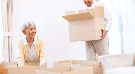 ダンボールに荷物を詰める夫婦