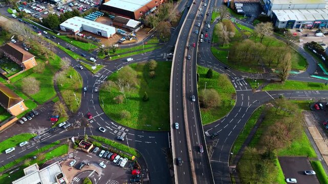aerial Birds Eye overhead shot over the Millbrook flyover roundabout in Southampton, Hampshire, England. Shot at sunset in winter with bright light shining as the cars pass over the industrial suburb.