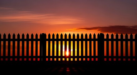 Obraz premium Vibrant sunset behind fence with warm orange glow