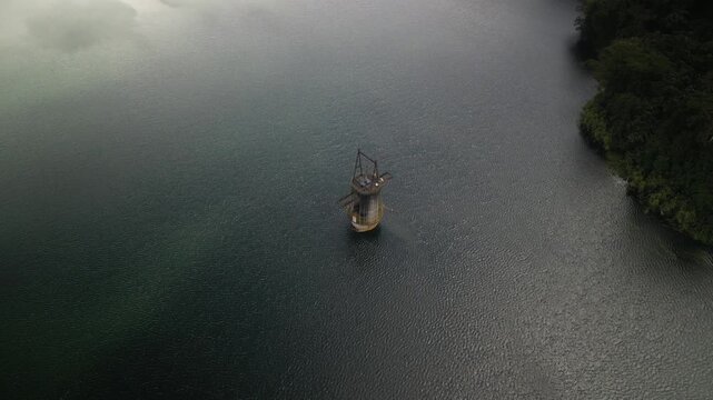 Aerial of bouy in lake lined with jungle hillsides in Costa Rica