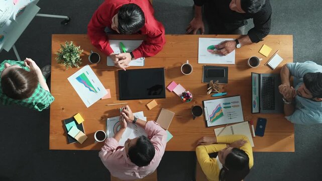 Top view of businesswoman sharing idea while stand at white board while manager asking question at table with tablet display financial graph. Attractive female leader pointing at board. Convocation.