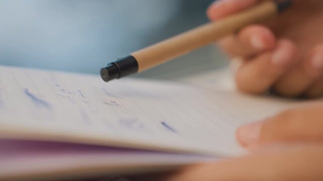 Handwritten note editing. Focusing on precise edits of handwritten pages with ink marks present. Carefully marking and correcting handwritten notes on lined pages during manuscript revision