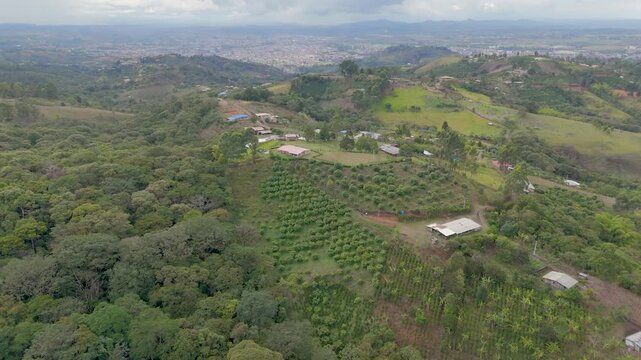 Bird's eye view showing lush green hills and scattered farmhouses under a cloudy sky in Popay&aacute;n.