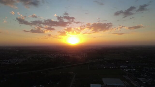 A stunning cinematic golden hour sunset over an industrial landscape and open fields.