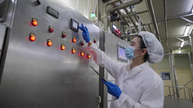 Canned food manufacturing industry, a female quality control officer using a tablet to inspect the accuracy of large machinery in a processed food production line according to international standards