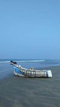 Traditional Artisanal Fishing Boat Resting on a Sandy Tropical Beach Shore at cox's bazar