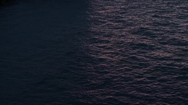 Calm ocean lightened by soft light, split shadow and warm sunlight over Atlantic