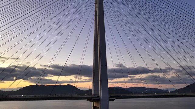 Geometric lines of Tatara Bridge cables with vibrant magic hour sky, full frame.多々羅大橋