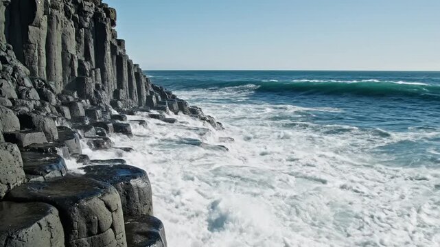 Powerful ocean waves crashing on unique basalt columns coastline