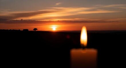 A Single Candle Flame Burns Brightly Against a Dramatic Sunset Sky.
