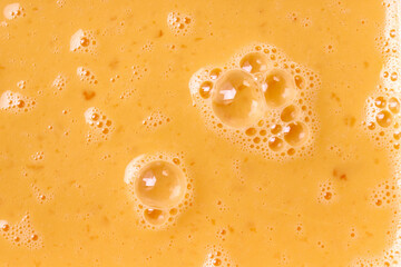 Fresh beaten eggs with bubbles as food background