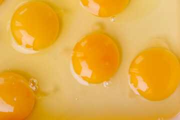 Fresh raw eggs with visible yolks on light background