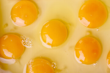 Fresh raw eggs with visible yolks on light background