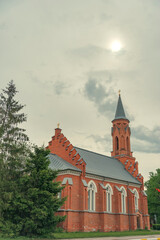  Neo-Gothic Holy Trinity Church in Rechitsa under misty sun with copy space