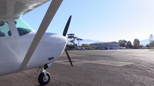 Ground crew coming around the plane parked in an airfield
