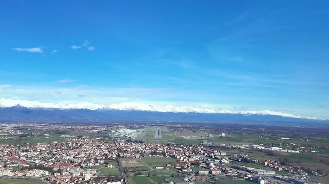 immersive pilot&rsquo;s eye view flying the final approach to Turin airport, with a view of the runway ahead, and snowed Alps in the background in a bright winter day.