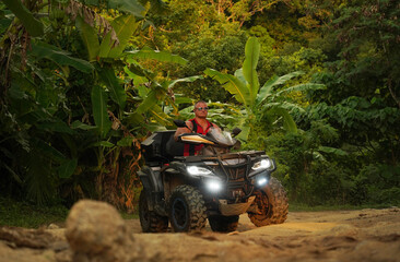 A man engages in extreme ATV riding on mountains in the evening