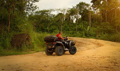 A man engages in extreme ATV riding on mountains in the evening © romaset