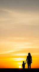 Fototapeta premium Silhouette of woman and child holding hands at sunset woman's day background download 2026 2027 orange 1