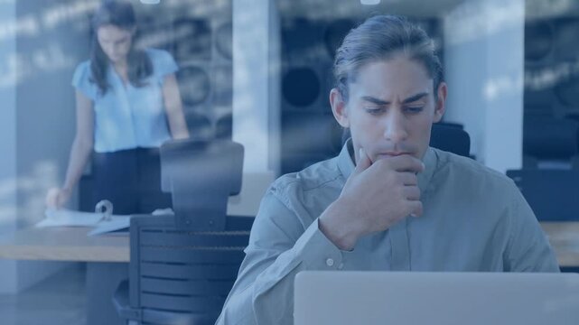Man thinking and typing while coworker sorting binder starting code overlay on laptop for analytics