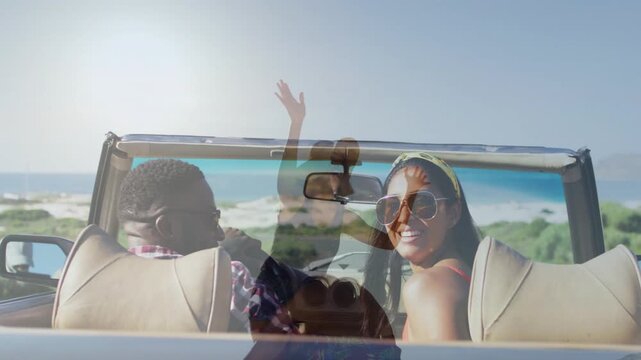 Passenger turning back and waving, driver laughing, faint hat overlaying convertible ocean travel