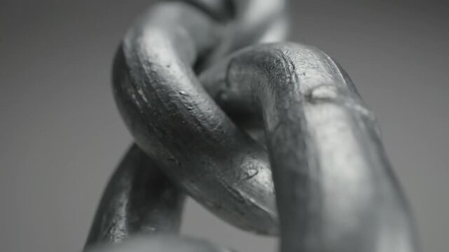Close up view of heavy metal chain links on grey background