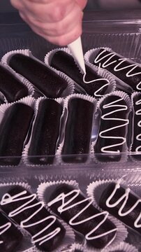 Decorate the cakes with white icing using a pastry bag. Vertical video