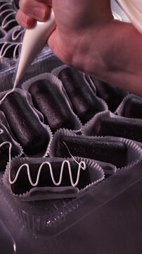 Decorate the cakes with white icing using a pastry bag. Vertical video