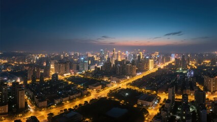 Obraz premium An aerial view of an urban dusk nightscape, where warm yellow street lamps interweave with a cool blue night sky, presenting the quiet beauty of a prosperous city, making it a material image suitable 