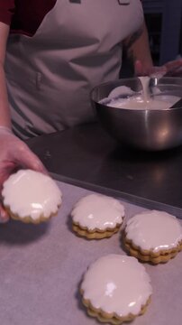 We prepare shortbread cookies with white icing. Vertical video.