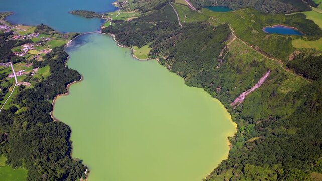 Sete Cidades Azores Aerial 4K. Drone elevation reveal of famous twin colored lakes in volcanic crater next to Boca do Inferno. Scenic Sao Miguel island green mountain valley landscape panorama