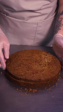 A female baker cuts a sponge cake to bake a cake.