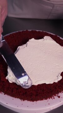 The process of making sponge cake. The concept of making confectionery desserts. The pastry chef applies the cream to the cakes.