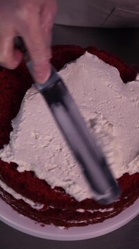 The process of making sponge cake. The concept of making confectionery desserts. The pastry chef applies the cream to the cakes.