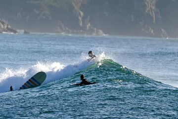 Obraz premium Wild Atlantic, landscape with surfers from Esmelle surf beach, Ferrol, Spain January 12, 2026