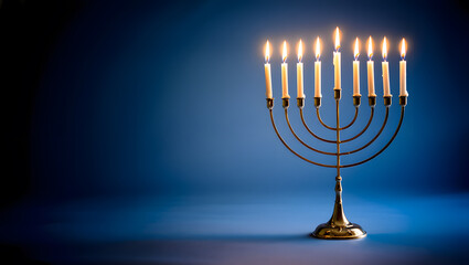 Fototapeta premium A lit menorah with nine candles glowing brightly against a deep blue background.