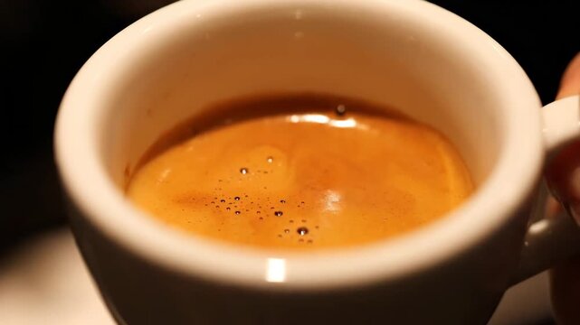 Extreme Close-Up Shot of Fresh Espresso Coffee with Perfect Golden Crema in a White Ceramic Cup, Capturing the Rich Texture and Quality of the Brew