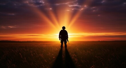 Obraz premium Soldier Silhouette Against Setting Sun in Field