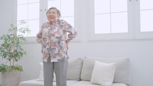 椅子から立つシニア女性