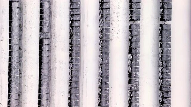 Close view of vertical white columns and textured brick surfaces creating a repetitive architectural pattern