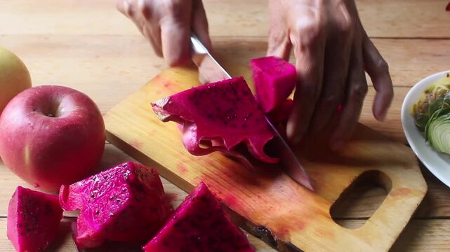 slicing dragon fruit on a chopping board