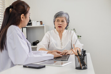 Fototapeta premium Senior doctor healthcare consultation with elderly patient in clinic, female physician uses laptop technology for digital health diagnosis, advice, communication, trust, insurance plan, private care