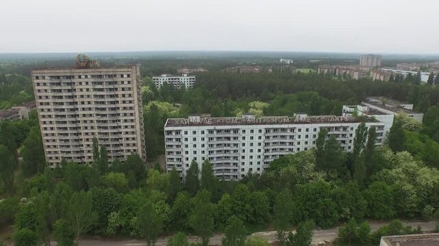 Abandoned apartment blocks in Pripyat, Chernobyl Exclusion Zone, overgrown with trees.
