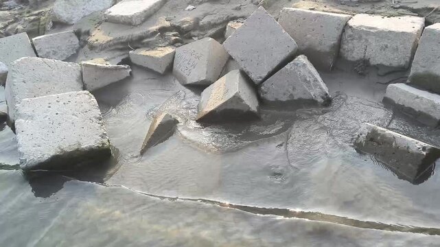 Concrete Blocks Submerged In Murky Water With Ripples