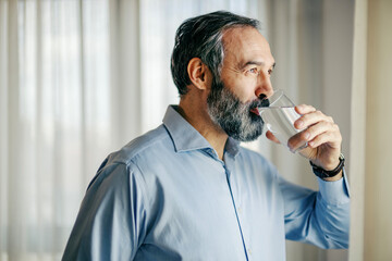 Mature man drinking water for healthy hydration