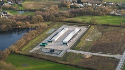 Aerial drone view of a high-capacity battery energy storage system (BESS) facility, showcasing modular grid-scale storage units in the UK. © Liam Carter